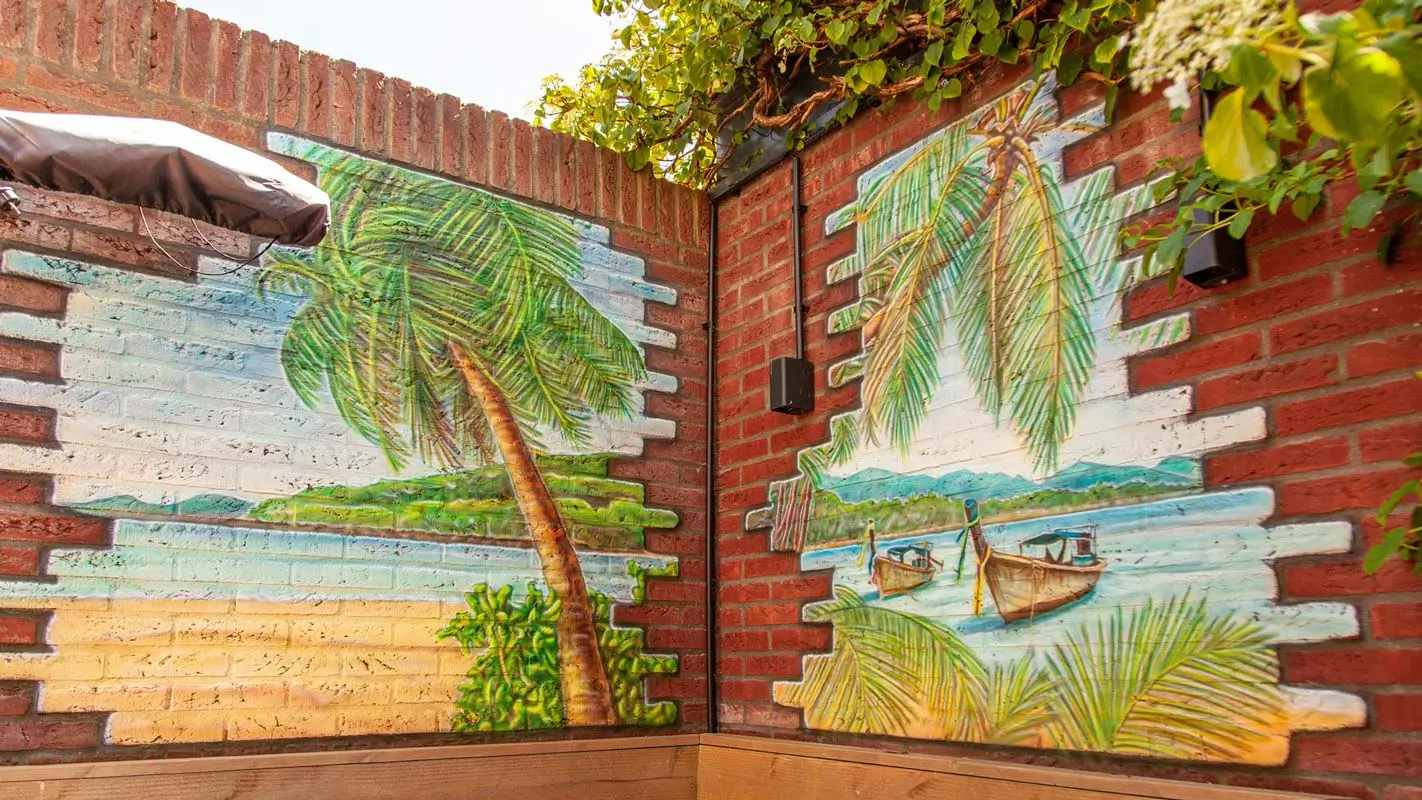 Airbrush muurschildering met palmbomen en strand in de tuin